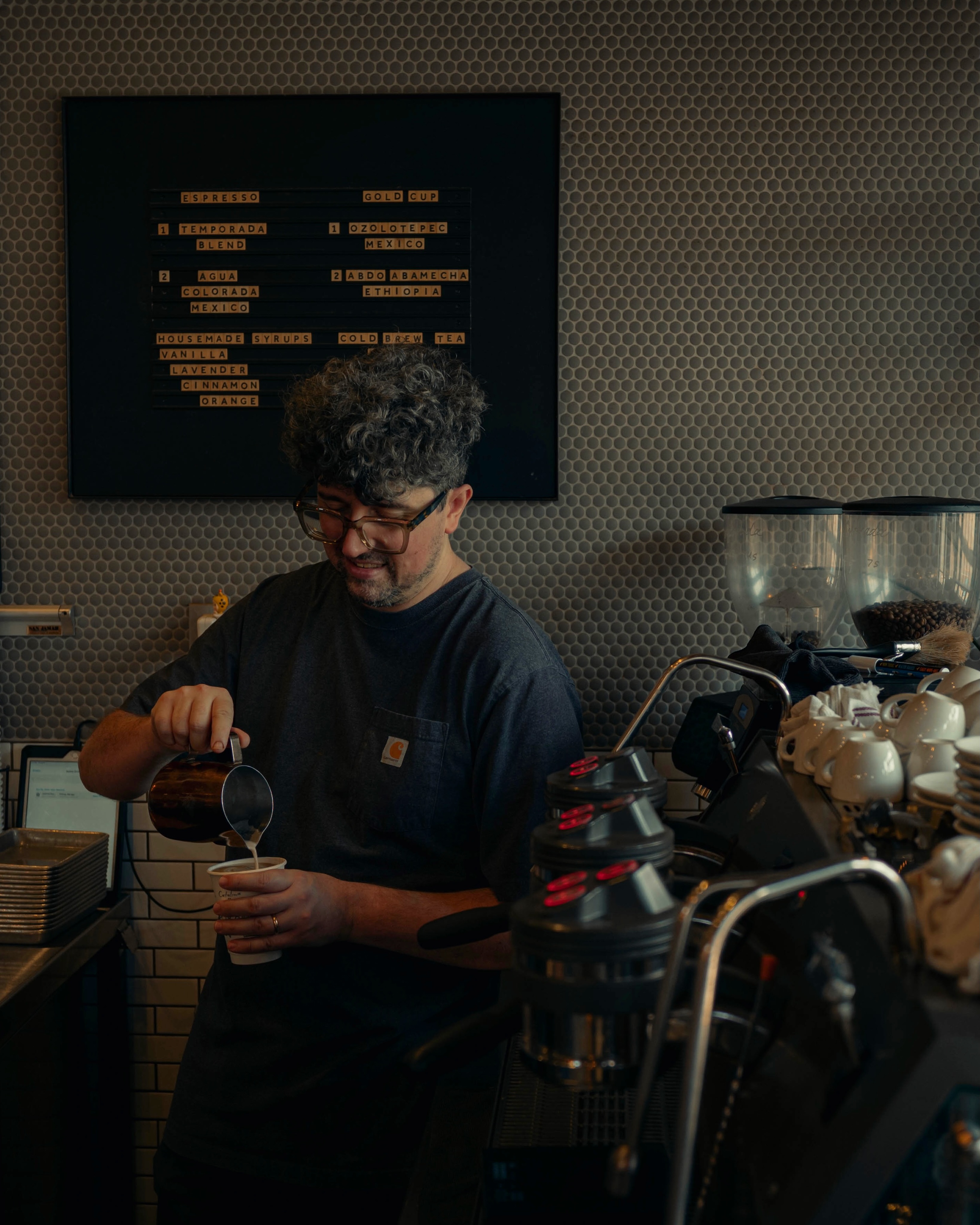 A Catalina Coffee barista pouring milk into a drink