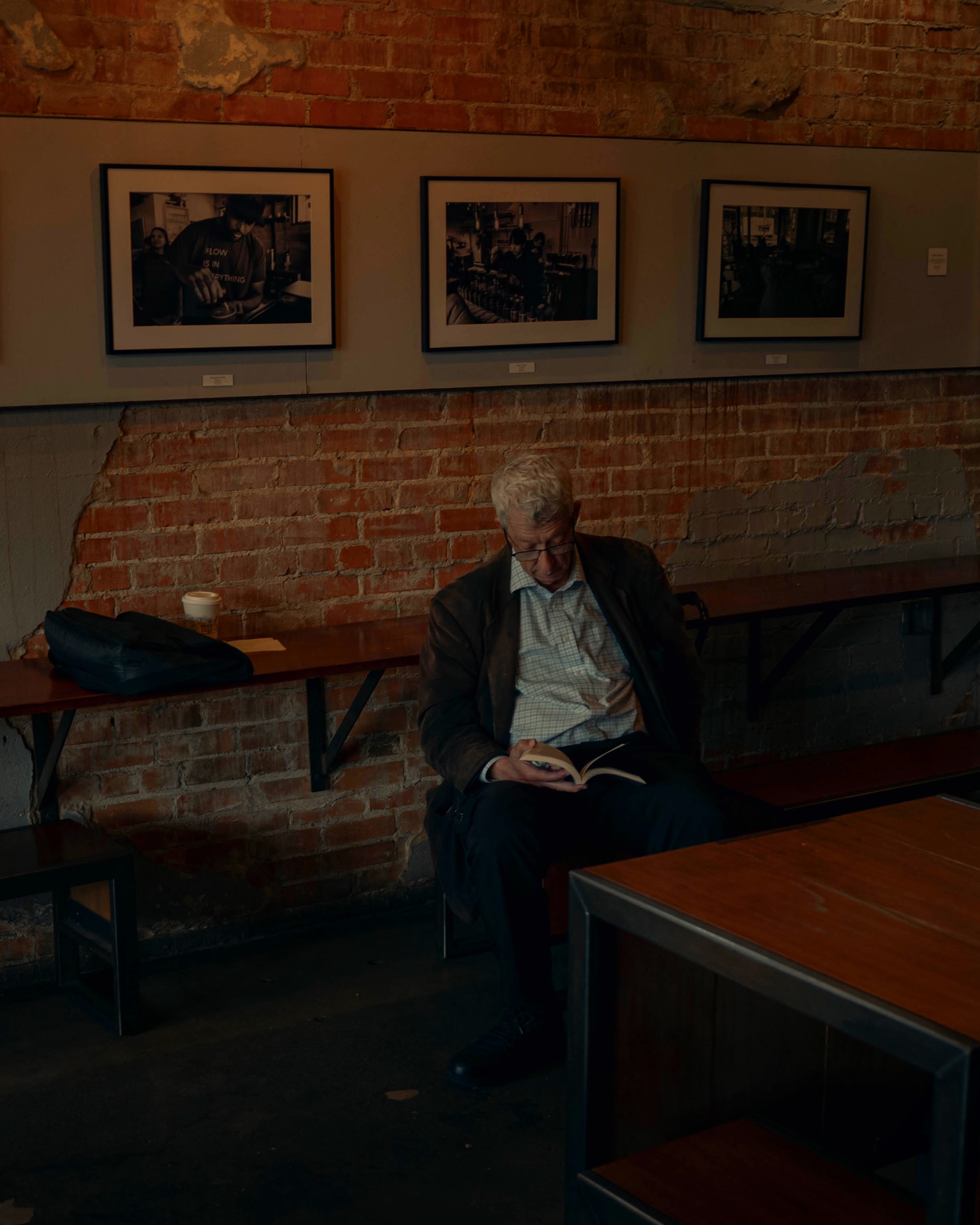 A customer reading beside Catalina Coffee's exposed brick wall